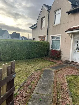 a house with a hedge in front of it at Rowan in Bellshill