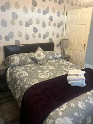 a bedroom with a bed with towels on it at Rowan in Bellshill
