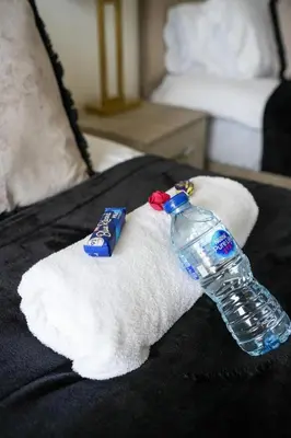 a bottle of water sitting on top of a towel at 2 BDR Apartment By Caledonia Luxe Stays Short Lets & Serviced Accommodation Airdrie in Airdrie