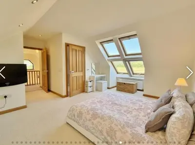 a large bedroom with a bed and a large window at Sealladh Mor-Cottage in Lamlash, Arran in Lamlash