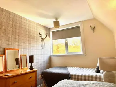 a bedroom with a bed and a mirror and a window at Four Woodside in Craighouse