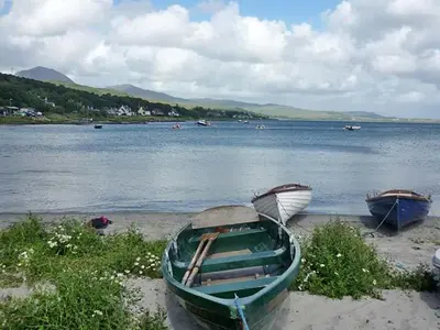 two boats on the shore of a body of water at Four Woodside in Craighouse