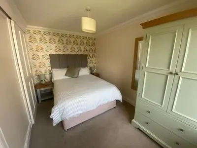 a bedroom with a bed and a dresser at Four Woodside in Craighouse