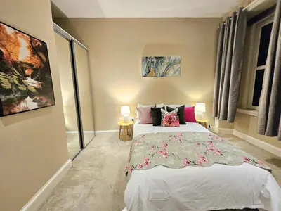 a bedroom with a bed and two lamps in it at 2 Bedroom Apt, 4 Beds, 3 TV near Fountain Park in Edinburgh