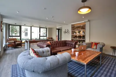 a living room with couches and a table with a laptop at For Students Only - The Ballet School in Glasgow in Glasgow