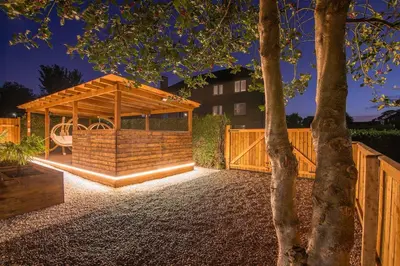 a wooden gazebo in a yard with a tree at Private Hot Tub - Zen & Bubbles in Edinburgh