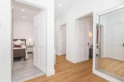 a mirror in a white room with a bedroom at Private Hot Tub - Zen & Bubbles in Edinburgh