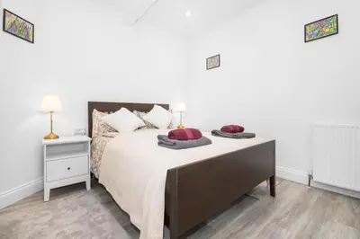 a bedroom with a large bed with red pillows on it at Private Hot Tub - Zen & Bubbles in Edinburgh