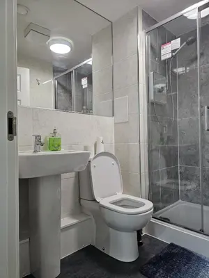 a bathroom with a toilet and a sink and a shower at Stylish 2-Bed Flat with Open-Plan Living plus Parking in Edinburgh