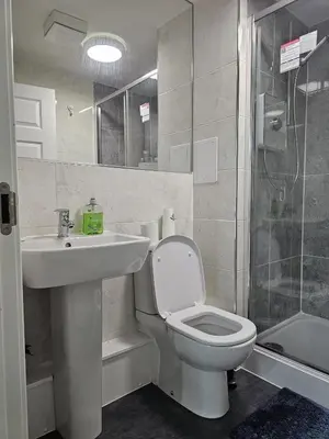a bathroom with a toilet and a sink and a shower at Stylish 2-Bed Flat with Open-Plan Living plus Parking in Edinburgh