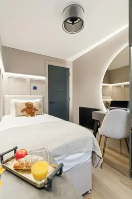 a bedroom with a bed with a tray of food and orange juice at 2BR West End Apartment Near Botanic Gardens in Glasgow