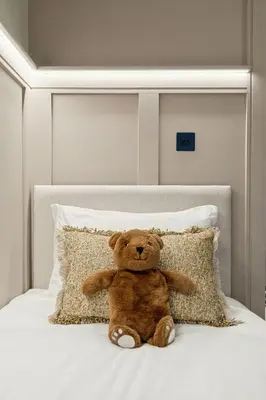 a teddy bear sitting on top of a bed at 2BR West End Apartment Near Botanic Gardens in Glasgow