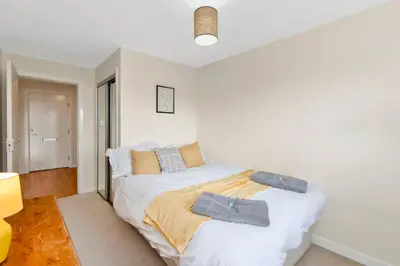 a white bedroom with a bed with pillows on it at Free Parking - Central - 2 Bedroom - 4 Guests in Livingston