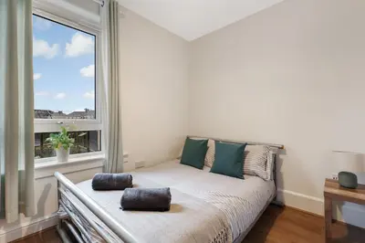 a bed in a room with a large window at Free Parking - Central - Sleeps 6 - Great Location in Armadale
