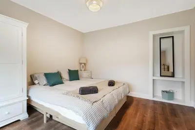 a bedroom with a large white bed with green pillows at Free Parking - Central - Sleeps 6 - Great Location in Armadale