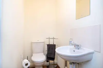 a white bathroom with a toilet and a sink at 4 Bedroom Townhouse In Stirling in Stirling