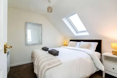 a bedroom with a large white bed and a window at 4 Bedroom Townhouse In Stirling in Stirling