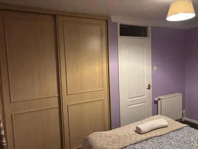 a bedroom with a closet and a bed with a pillow at OakHouse- Entire 3 Bedroom Terrace House with Free Parking in Cumbernauld