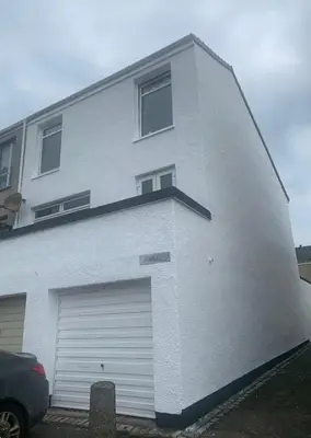 a large white building with a garage door at OakHouse- Entire 3 Bedroom Terrace House with Free Parking in Cumbernauld