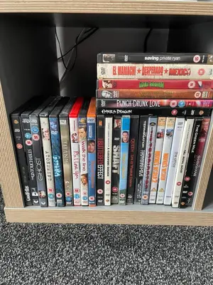 a shelf filled with dvds and other books at Spacious two bedroom flat, entire property in Greenock