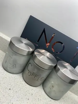 three silver cups sitting next to a blue box at Coorie Cottage in Edinburgh