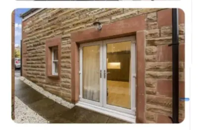a brick building with a door on the side of it at Coorie Cottage in Edinburgh