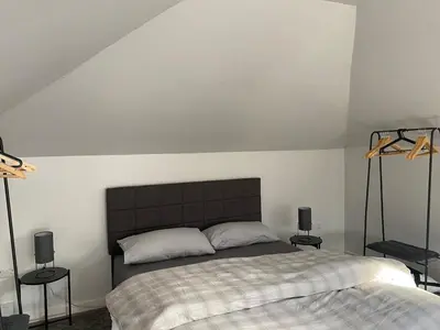 a bedroom with a bed and two tables and two speakers at Coorie Cottage in Edinburgh