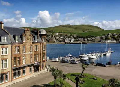 a building next to a body of water with boats at Kintyre apartment in Campbeltown