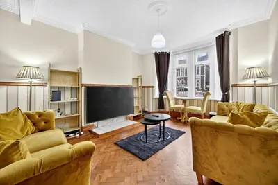 a living room with two couches and a flat screen tv at Spacious 5BR Home in Cardiff Bay with Office Area in Moffat