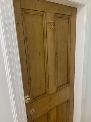 a wooden door in a room with a white wall at Andy's Pad in Edinburgh