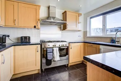 a kitchen with wooden cabinets and a stove at Southend perfect Stays in Moffat