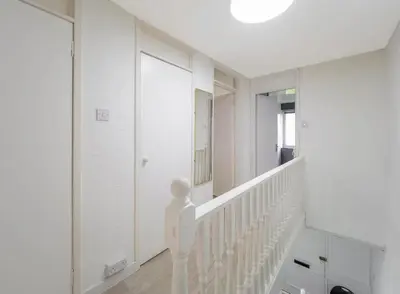 a white staircase in a house with white walls at Free Parking - 3 Bedrooms - Sleeps 7 - Airport in Paisley