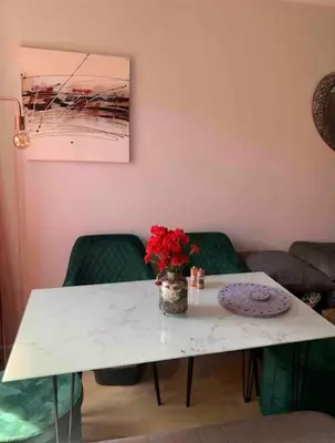 a white table with a vase of red flowers on it at City Centre Double Room in Glasgow