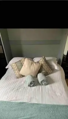 a white bed with towels and pillows on it at City Centre Double Room in Glasgow