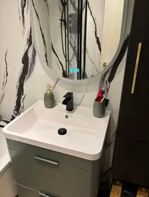 a bathroom with a white sink and a mirror at City Centre Double Room in Glasgow