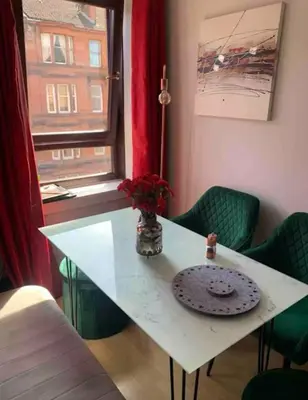 a white table with a vase of flowers on it at City Centre Double Room in Glasgow
