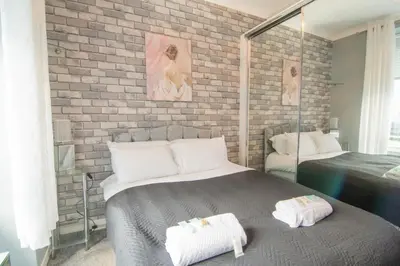 a bedroom with a bed and a brick wall at Central Renfrew 1BR Apt in Renfrew