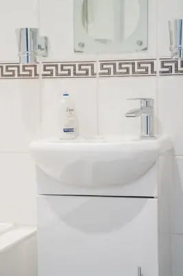 a white bathroom with a sink and a mirror at Central Renfrew 1BR Apt in Renfrew