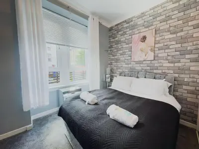 a bedroom with a large bed with two pillows on it at Central Renfrew 1BR Apt in Renfrew