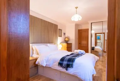 a bedroom with a bed and a desk and a mirror at Bright, spacious house in Edinburgh