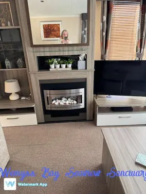 a living room with a fireplace and a tv at Wemyss Bay Seaview Sanctuary in Wemyss Bay