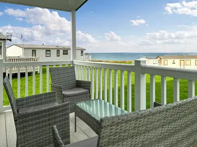 a balcony with chairs and a table and the ocean at Ocean Bay View - Ukc7143 in Ayr