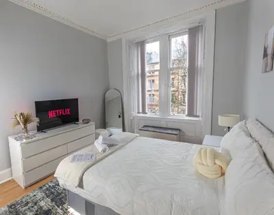 a white bedroom with a bed and a tv at FREE Pool Table Cinema Room TableTennis AirHockey Glasgow City in Glasgow