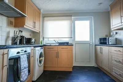 a kitchen with a washing machine and a window at Castlehill House in Boʼness