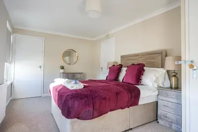 a bedroom with a large bed with purple blankets at Castlehill House in Boʼness