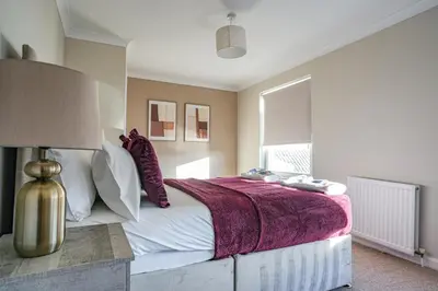 a bedroom with a large bed with a purple blanket at Castlehill House in Boʼness