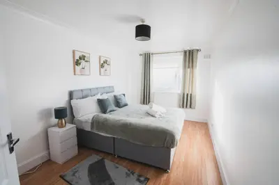 a bedroom with a bed and a window at Modern 3BR Flat with Parking in Renfrew