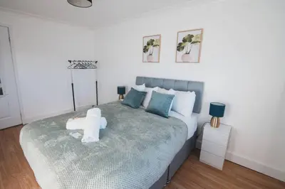 a bedroom with a bed with a stuffed animal on it at Modern 3BR Flat with Parking in Renfrew