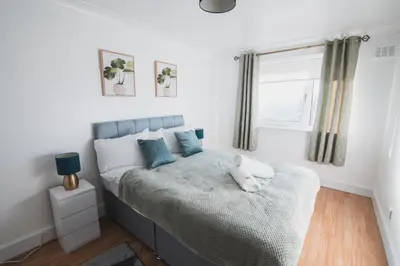 a bedroom with a bed with a teddy bear on it at Modern 3BR Flat with Parking in Renfrew