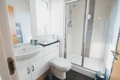 a bathroom with a toilet and a sink and a shower at Top-Floor 2-Bed Near Braehead in Renfrew